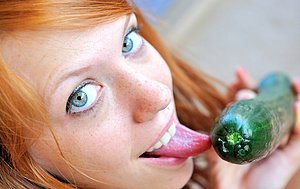 Two girls sharing a cucumber as if it\'s a double-sided dildo