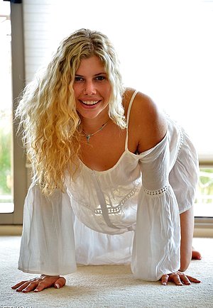 Frizzy-haired blonde fucking her own pussy with a large cucumber